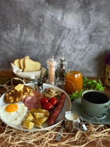 a table with a plate of food with eggs sausage and bread at Elysian Airport Hotel & Restaurant in Arnavutköy +96 photos