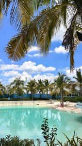 una grande piscina con palme su una spiaggia di Kaiah's Haven at Azure North San Fernando Pampanga a San Fernando Altre 6 foto