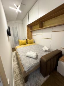 a bedroom with a large bed with yellow pillows at I&I Bubanj in Kragujevac