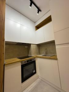 a kitchen with white cabinets and a sink at I&I Bubanj in Kragujevac +2 photos