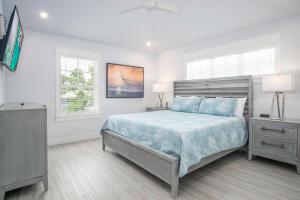 ein weißes Schlafzimmer mit einem Bett und zwei Fenstern in der Unterkunft Heart of Morada in Islamorada + 87 Fotos