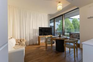 a living room with a table and a tv at BLOOM-Living in Linz
