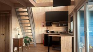 a room with a kitchen with a spiral staircase at Domki Rekreacyjne "Błękitne Wzgórze" in Żałe