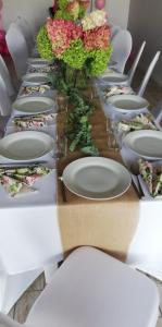 DługiePensjonat Długie Lubuskie的一张长桌子,上面有白色的板子和花