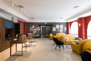 a waiting area with yellow chairs and a waiting room at B&B Hotel Palermo Quattro Canti in Palermo