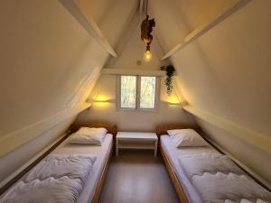 two beds in a small room with a window at Chalet Séquoia 140, nature, piscine,dogfriendly in Durbuy +22 photos