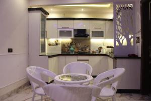 een keuken met witte stoelen en een tafel en een aanrecht bij The Blessings Annexe in Nainital