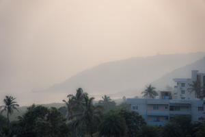 Una vista brumosa de una ciudad con palmeras y una montaña. en Blue Horizon - 3BHK Sea Facing Spacious Stay, en Visakhapatnam 9 fotos más