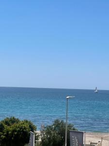 a street light on the beach with a sail boat in the water at Altea Beach in Altea