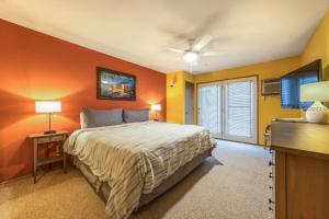 a bedroom with orange walls and a bed and a tv at 15 Lodge in Hood River