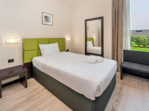 a bedroom with a large bed and a mirror at B&B HOTEL Park Hotel Cassano in Cassano dʼAdda +34 photos