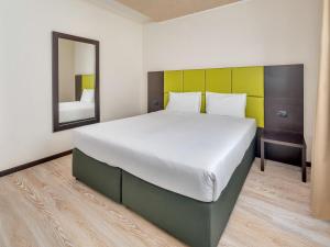 a large bed in a room with a mirror at Park Hotel Cassano in Cassano dʼAdda +15 photos