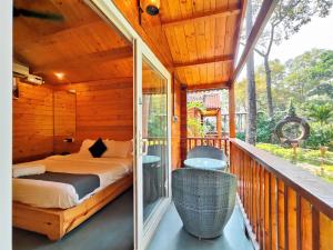 a bedroom on a porch with a bed on a balcony at Tranquill riverview resort by trideus-Saipem, Candolim in Candolim +92 photos