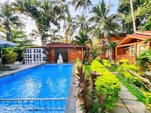 a swimming pool in front of a house at Trideus Tranquil riverside resort -Saipem, Candolim in Candolim