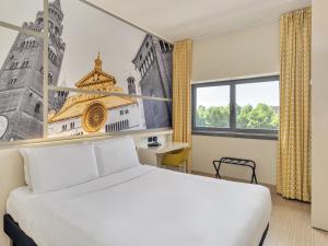 a bedroom with a white bed and a large window at B&B Hotel Cremona in Cremona