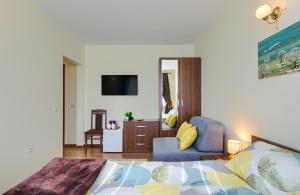 ein Schlafzimmer mit einem Bett, einer Couch und einem Stuhl in der Unterkunft Rila North Samokov in Samokow
