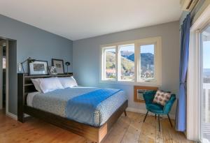 a bedroom with blue walls and a bed and a chair at Grandview Get-A-Way in White Salmon