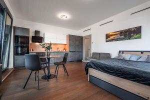 a bedroom with a bed and a table and a kitchen at Šantovka Residence in Olomouc