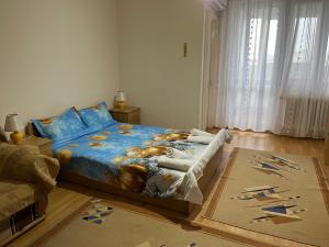 a bedroom with a bed with a blue comforter at Garsonieră Brazda lui Novac in Craiova