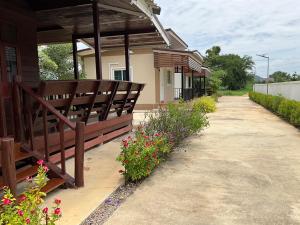 a porch of a building with benches and flowers at คีรินรีสอร์ท 2 in Ratchaburi