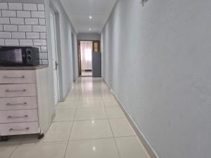 pasillo vacío con cocina y microondas en Maglovir Economy, en Tiervlei