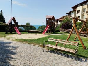 ein Park mit einer Bank, Rutschen und einem Spielplatz in der Unterkunft Garden of Eden- Apartments Sweet Dreams Rey&Mar Saint Vlas in Sweti Wlas