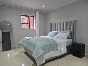 Un dormitorio con una cama grande y una ventana. en Maglovir Economy, en Tiervlei 4 fotos más