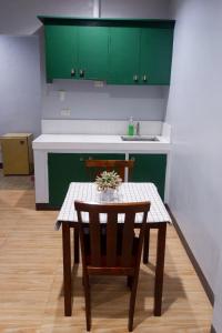 a small kitchen with a table and green cabinets at Arcova Residences 2BR Apartment in San Carlos