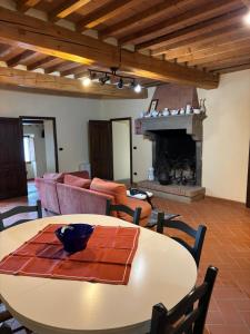 a living room with a table and a fireplace at Borgo La Valle in Palazzo del Pero