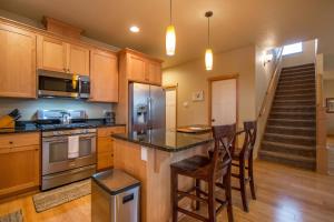 een keuken met houten kasten en een eiland met barkrukken bij Redtail 30 day minimum in Hood River