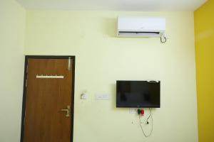 a room with a door and a television on a wall at Laxmi Palaze in Tallākulam