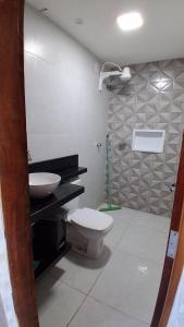 un baño con inodoro y lavabo en Chalé Lá Aurora, en Guaramiranga