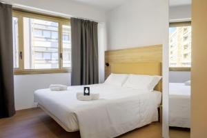 a bedroom with a large white bed and a window at B&B HOTEL Catania City Center in Catania