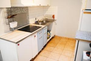 a small kitchen with white cabinets and a sink at Grand F2 Saint Maur in Saint-Maur-des-Fossés