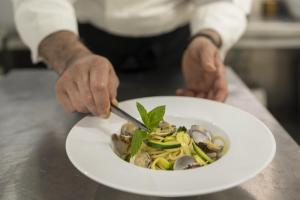 una persona cortando un plato de comida con un cuchillo en B&B HOTEL Diano Marina Palace, en Diano Marina