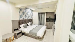 Un dormitorio con una cama y una mesa dentro. en Hotel A One, en Jāmb 1 foto más