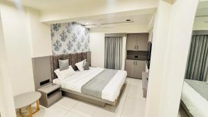 Un pequeño dormitorio con una cama y una cocina. en Hotel A One, en Jāmb