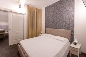 Emilia Suite Edition في مودينا: غرفة نوم بسرير ابيض وجدار