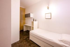 Dieses weiße Zimmer verfügt über ein Bett und einen Schreibtisch. in der Unterkunft Emilia Suite Edition in Modena