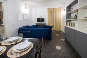 Emilia Suite Edition في مودينا: غرفة معيشة مع طاولة وأريكة زرقاء