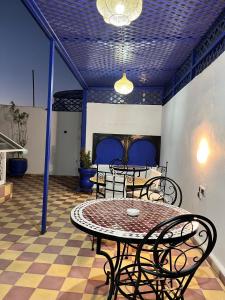 Riad Lalla Aicha في مراكش: فناء مع طاولة وكراسي في غرفة