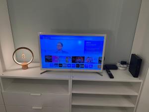 ein Flachbildfernseher auf einem Regal in der Unterkunft Studio Cosy, résidence sécurisée, parking privé in Pau + 12 Fotos