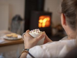 a woman is holding a bowl of whipped cream at Pearl & Spice Hideaways - 2 two bedroom cottages nearby - Part of the The Bay Filey Holiday Village with pool, gym and direct beach access, pub, restaurant, tennis and meadows walks in Reighton +67 photos