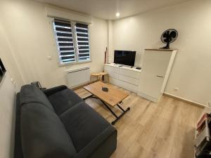 a living room with a couch and a table at Studio cozy à Lagnieu in Lagnieu