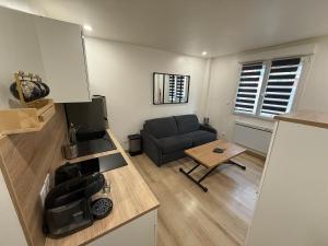 a living room with a couch and a table at Studio cozy à Lagnieu in Lagnieu