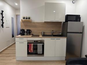 a kitchen with white cabinets and a refrigerator at Studio cozy à Lagnieu in Lagnieu +1 photo