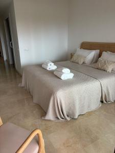 a bedroom with two beds with towels on them at Los Granados Stunning 2 Bed Beach Apartment in San Luis de Sabinillas