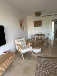 a living room with a chair and a table at Los Granados Stunning 2 Bed Beach Apartment in San Luis de Sabinillas