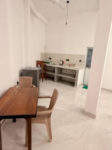 ein Wohnzimmer mit Tisch und Stühlen und eine Küche in der Unterkunft Pabalu House in Ahangama