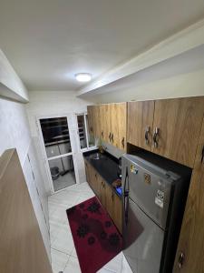 a kitchen with a stainless steel refrigerator and wooden cabinets at Appartement saada Agadir in Agadir +15 photos